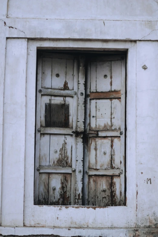 an old rundown building with a rusted old window