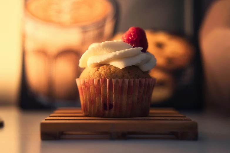 a small cupcake with icing, sprinkles and a straw