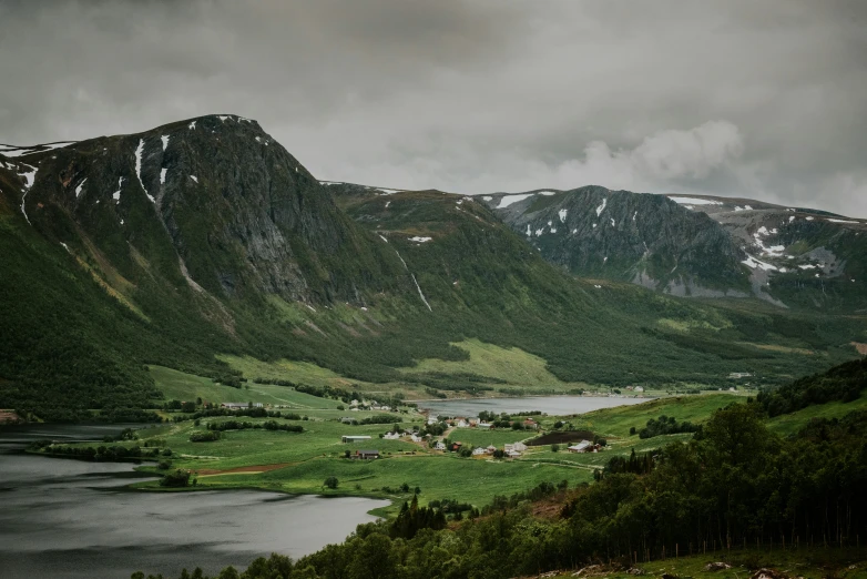 the mountains near a lake that has small homes