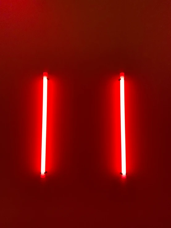 two red lights sitting on top of a red wall