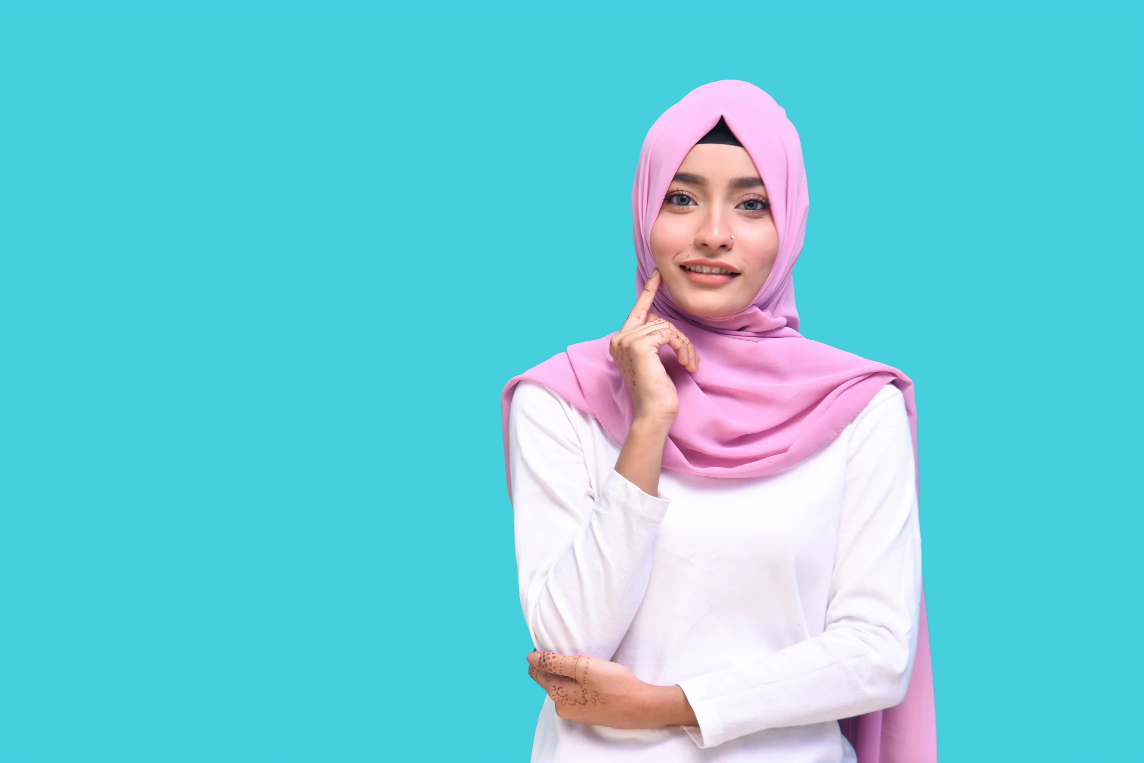 a woman posing for a po with a pink scarf over her head