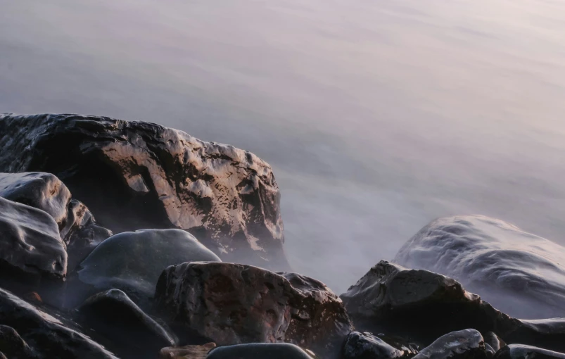 large rocks, ice and water on a rocky beach