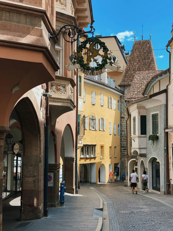 a cobblestone street in a european town with people