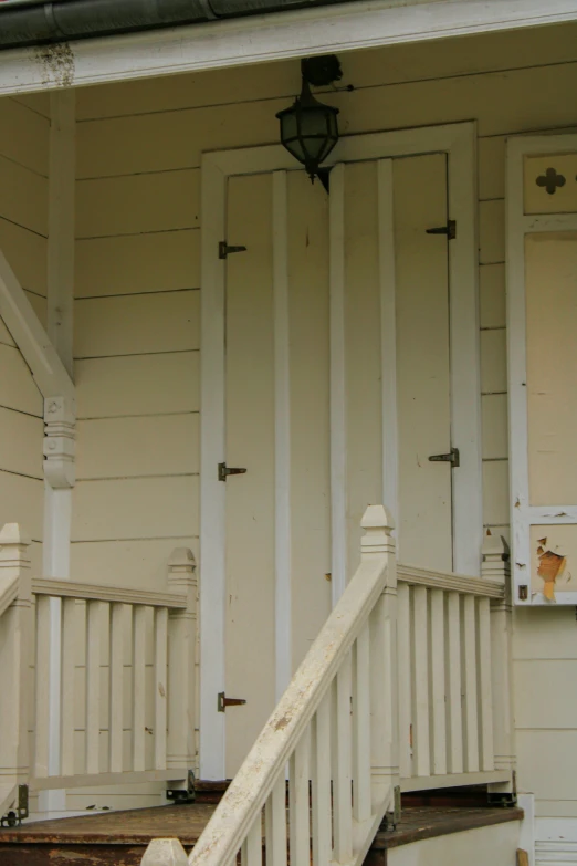 the front entrance to a large, old house with white trim