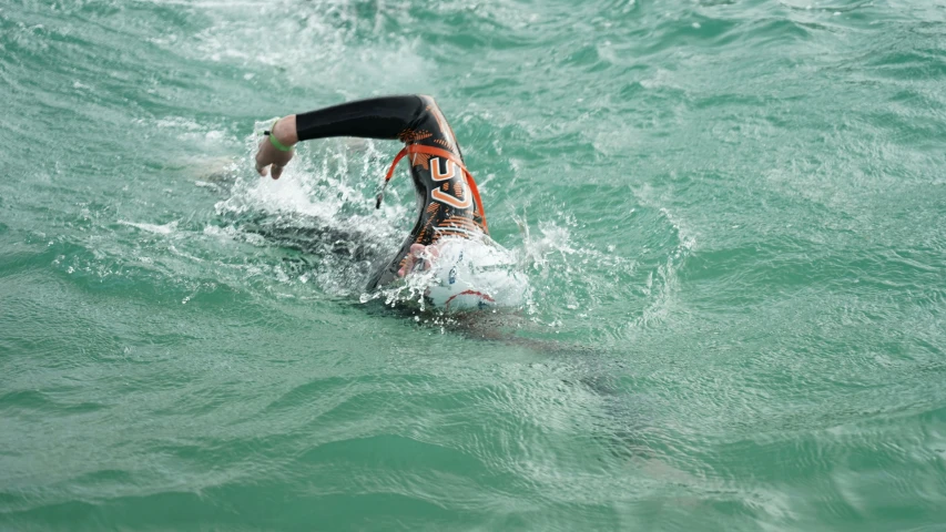 a person surfing through the water and having fallen off his surfboard