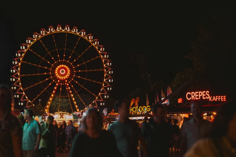 a group of people standing in front of a ferris wheel