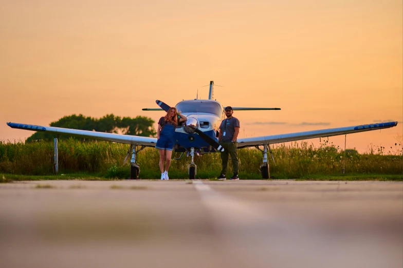 a couple is standing next to an airplane