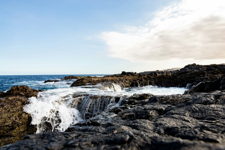 a man riding a wave machine down the side of a rock cliff