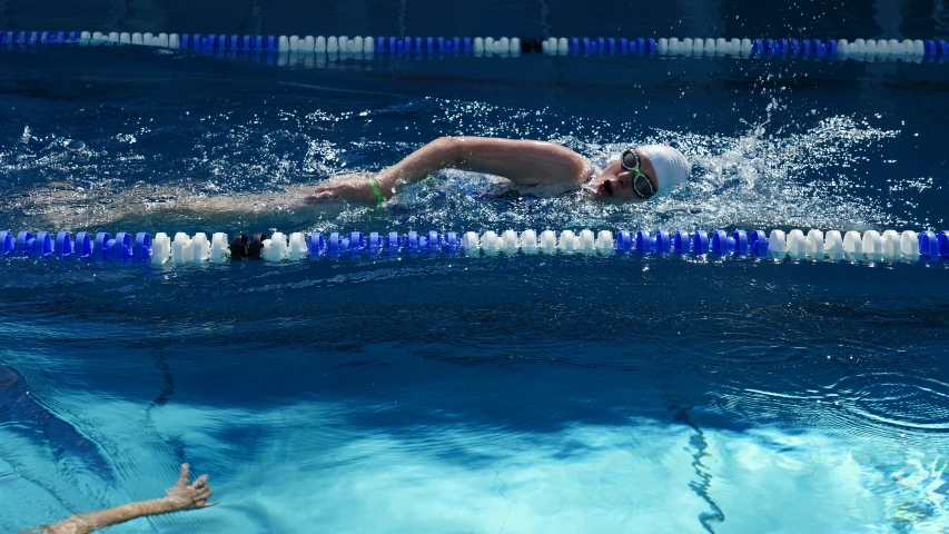 swimmer in motion starting to jump in blue swimming pool