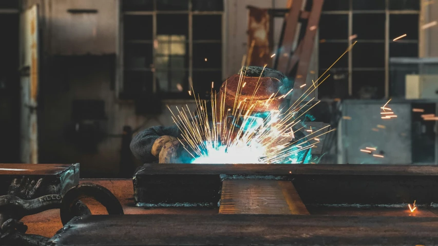 welder working in an assembly line with sparks