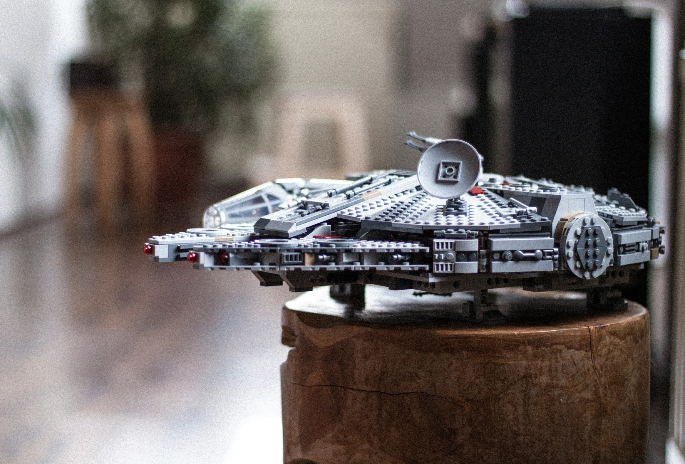 a lego star wars millennium falcon replica sits on a pedestal