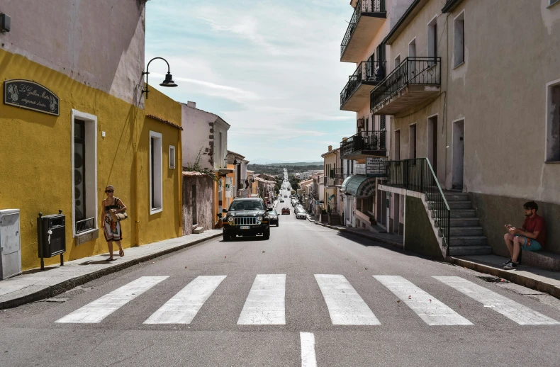 a man is sitting on the curb outside while another man waits