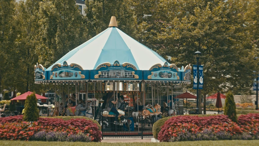 a colorful merry go round has many people gathered