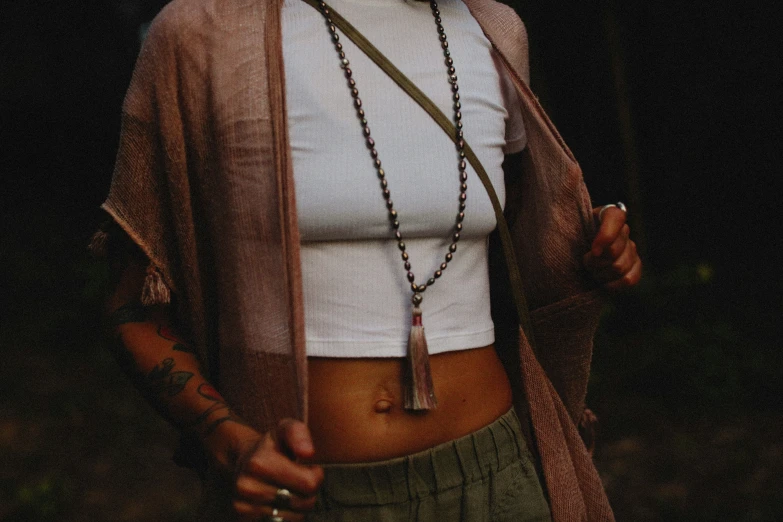 a woman is wearing a scarf, necklace and cardigan