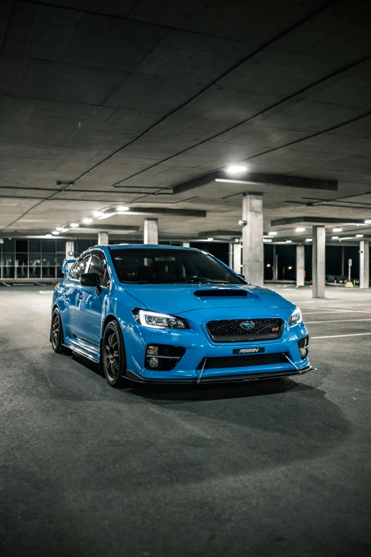 a blue car sits in the middle of an empty parking lot