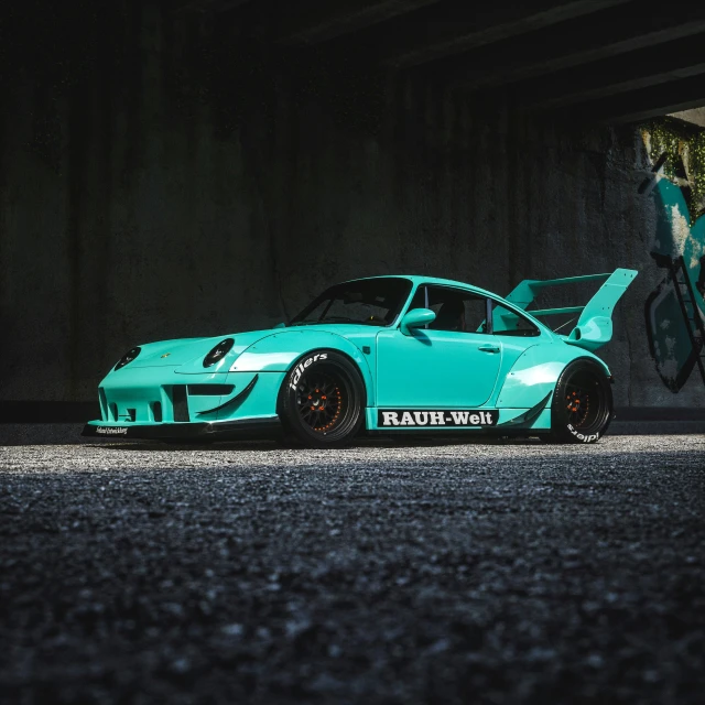 an aqua colored car in a dimly lit garage