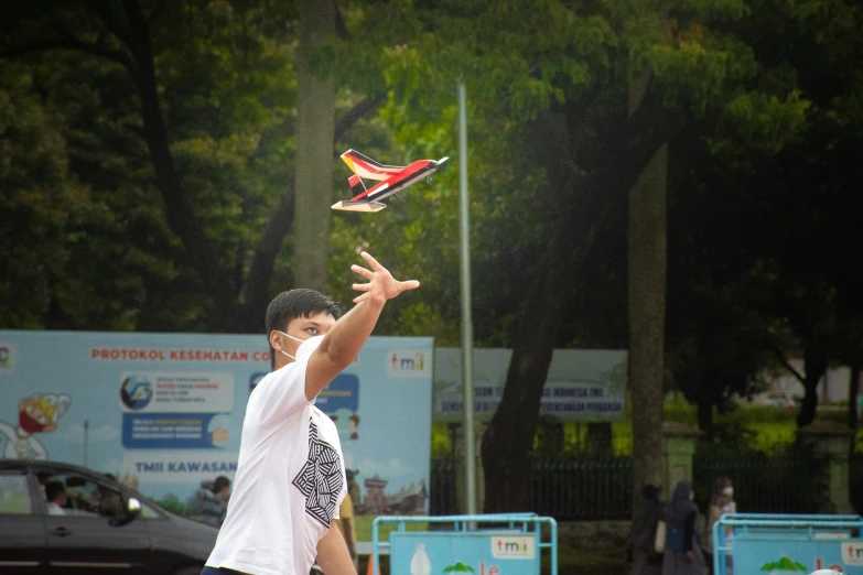 a man tossing a colorful kite in the air