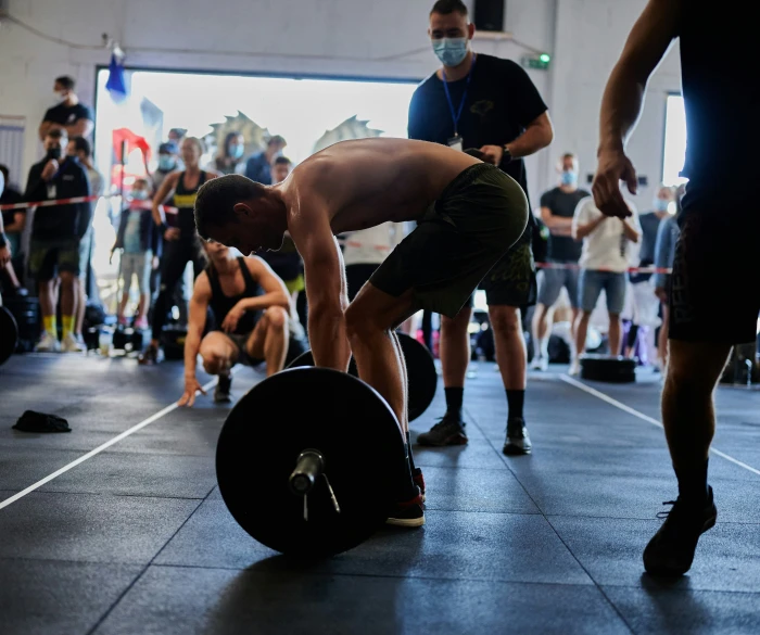 a group of men doing deadlift exercises with masks on