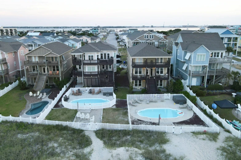 houses sitting on beach near a pool with sand surrounding them