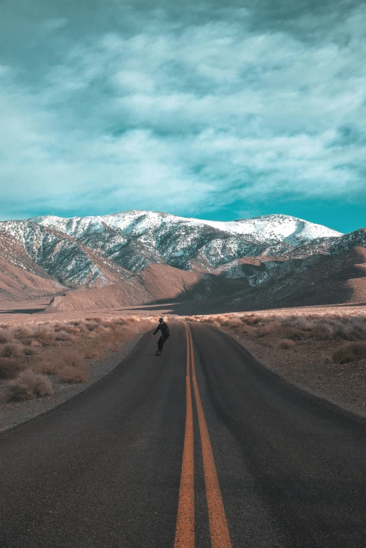 a lone man walking down a dirt road