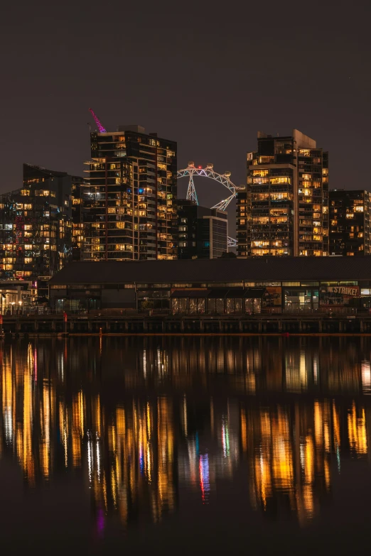 a night scene of some city buildings near water