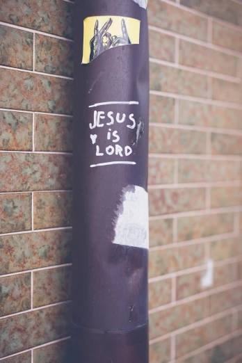a dark sticker that reads jesus is lord on it near a wall