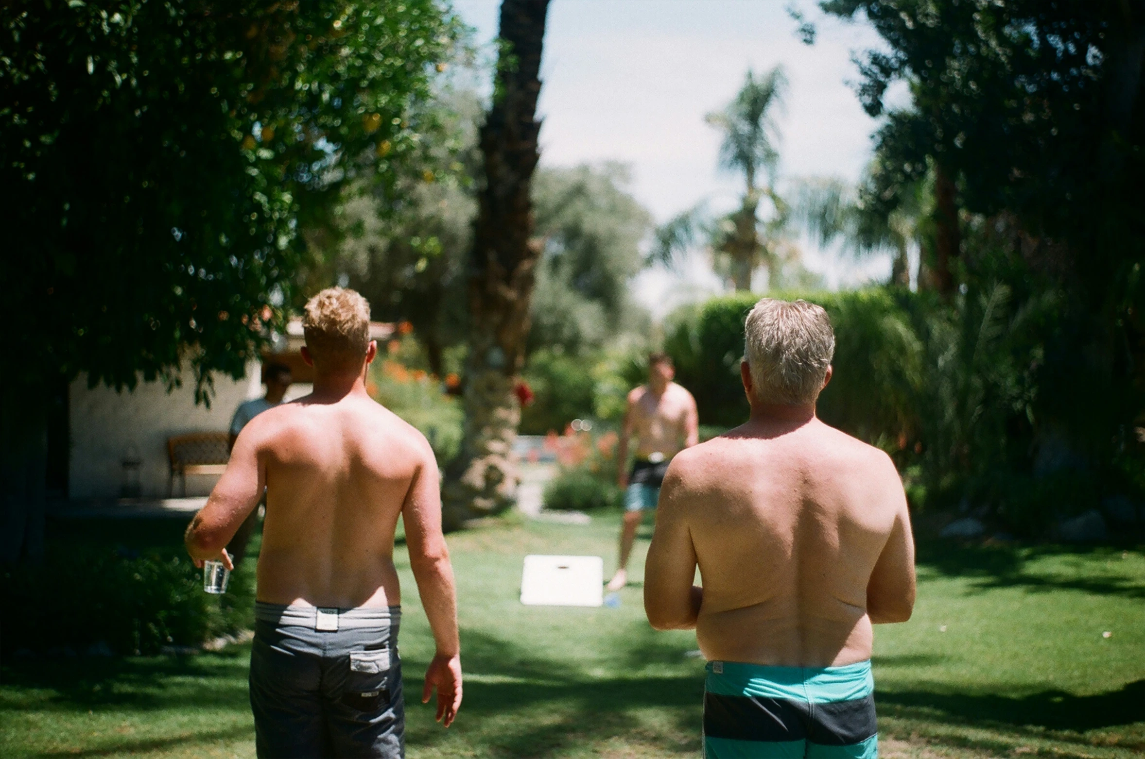 two people walking towards a grassy yard with s on