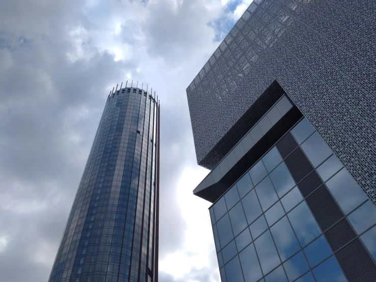 two tall building towering next to each other under clouds