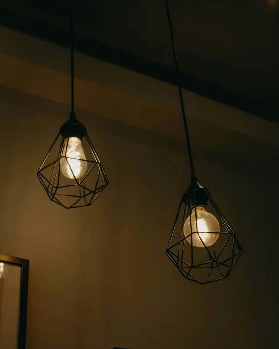 two hanging lights that are on a wall