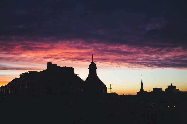 a church tower silhouetted against a colorful sunset