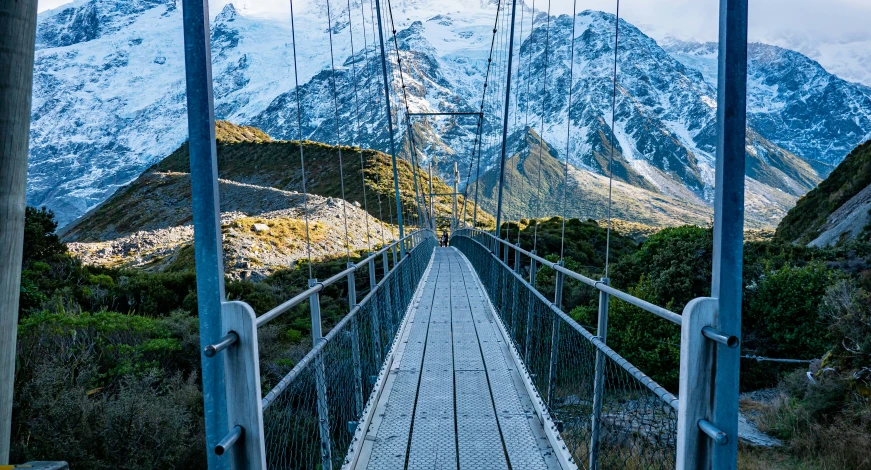 a suspension bridge with mountains in the background