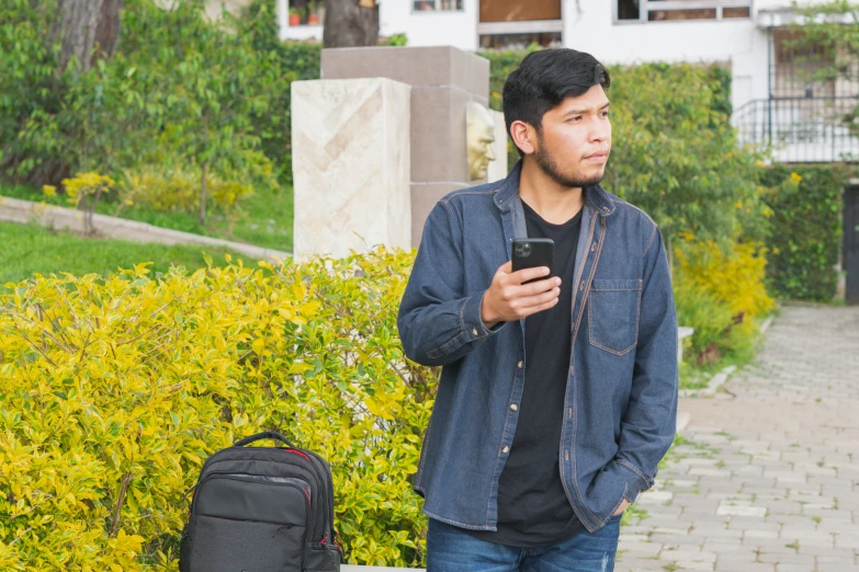 a young man standing in the street using a smart phone