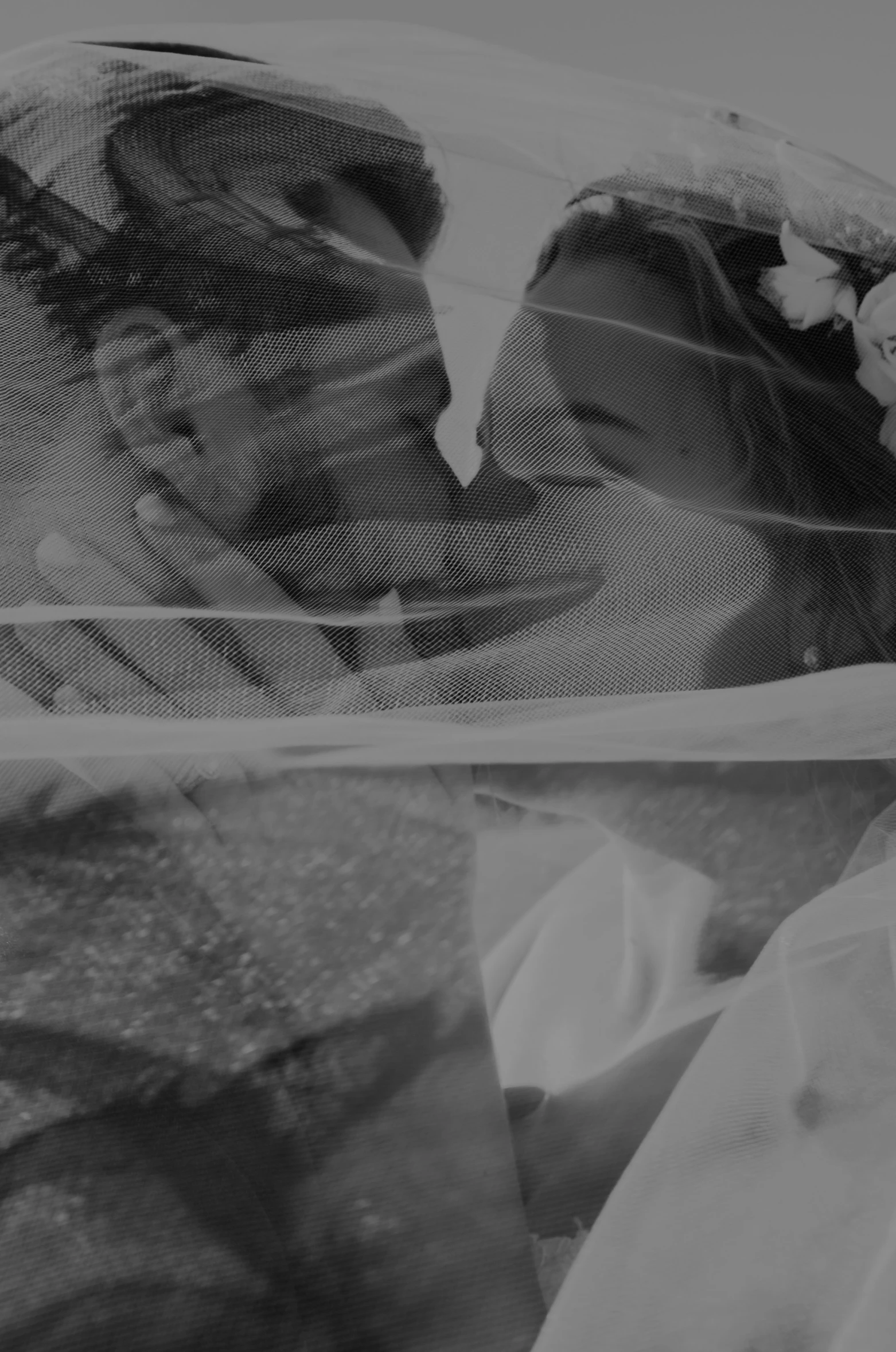 a black and white image of a bride with a veil covering her face