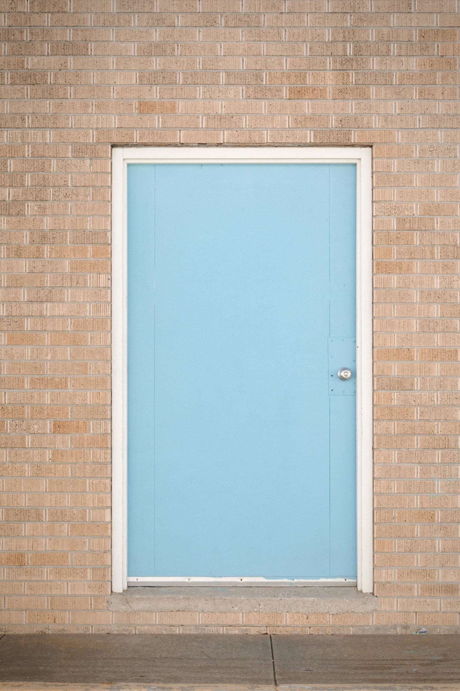 a blue door on a brick wall in the daytime