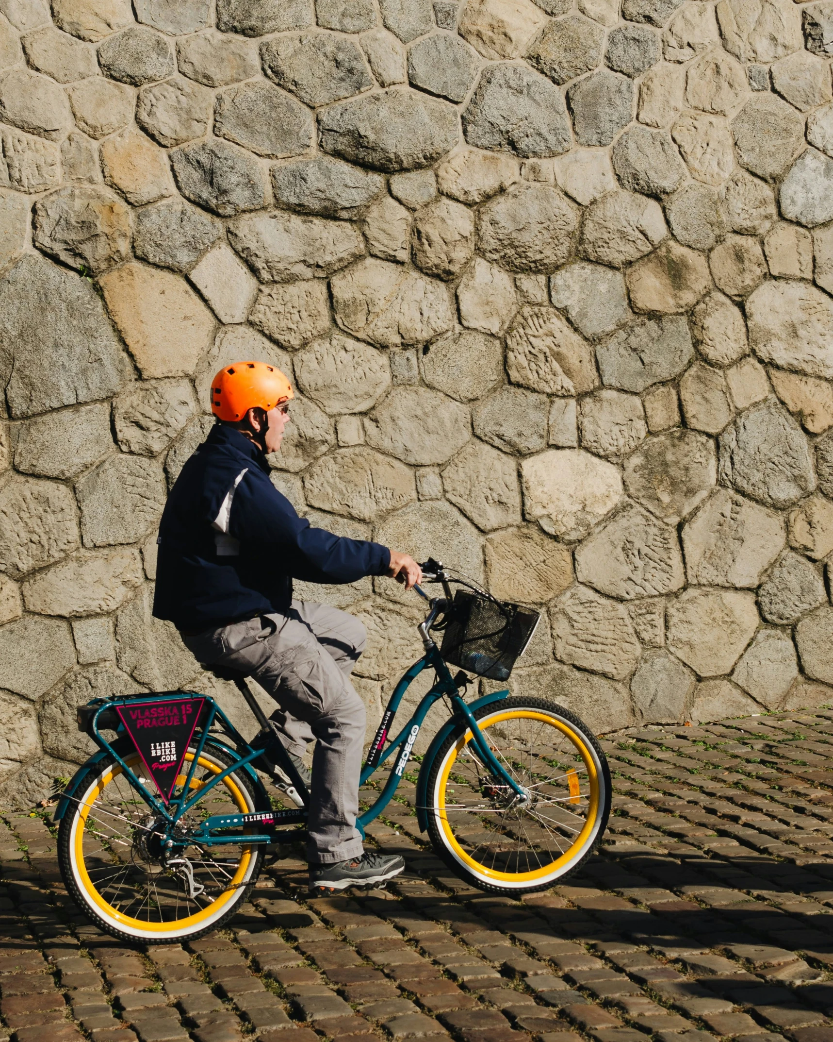 a man riding on a bike on a cobblestone road