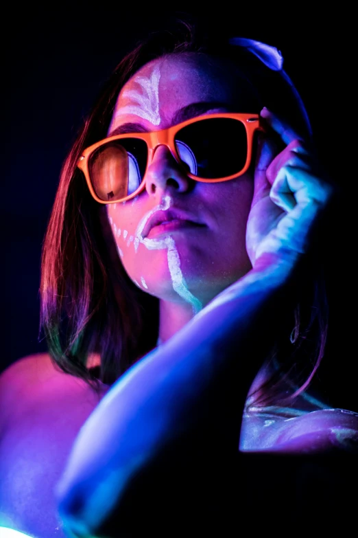 a girl with neon glasses holds her cell phone