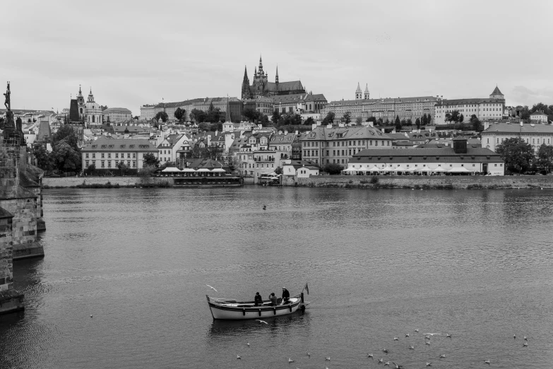 people in a boat on a river, some with large buildings