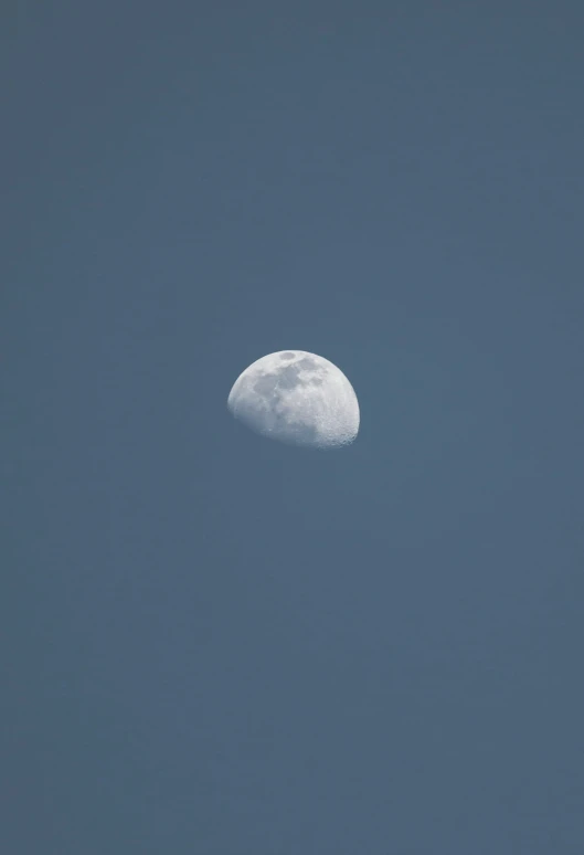 the moon is shown against a blue sky