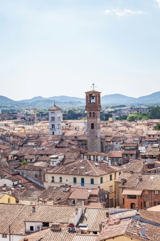 a big building with a clock tower next to some hills