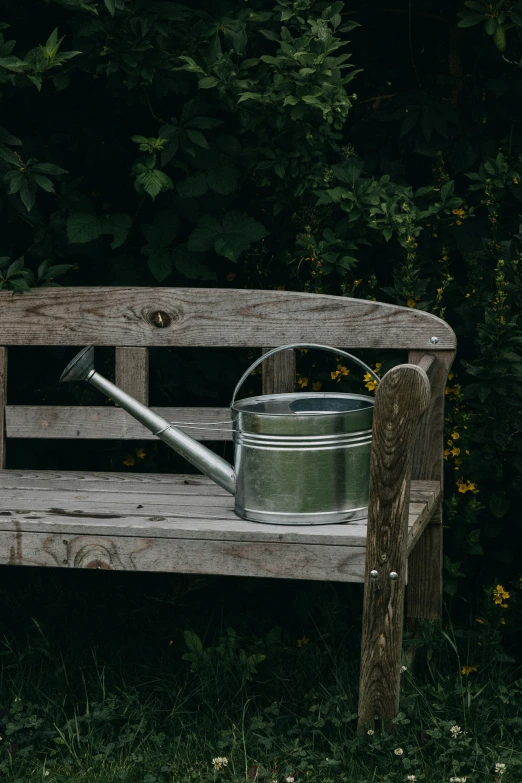 a bucket with a metal handle on an old wooden bench