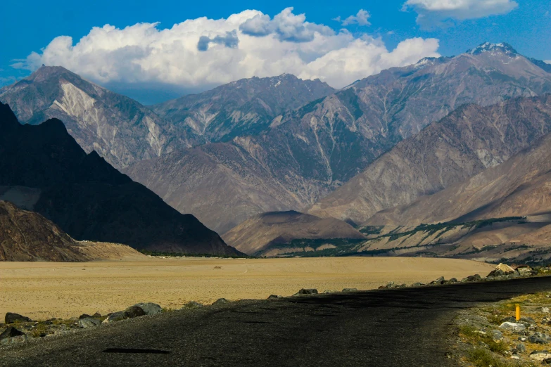 a very long road with some mountains in the back