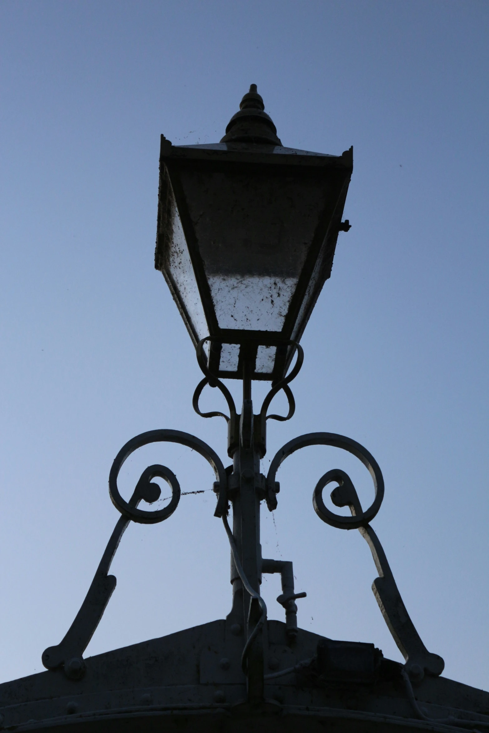 an old lamp post with two birds on it