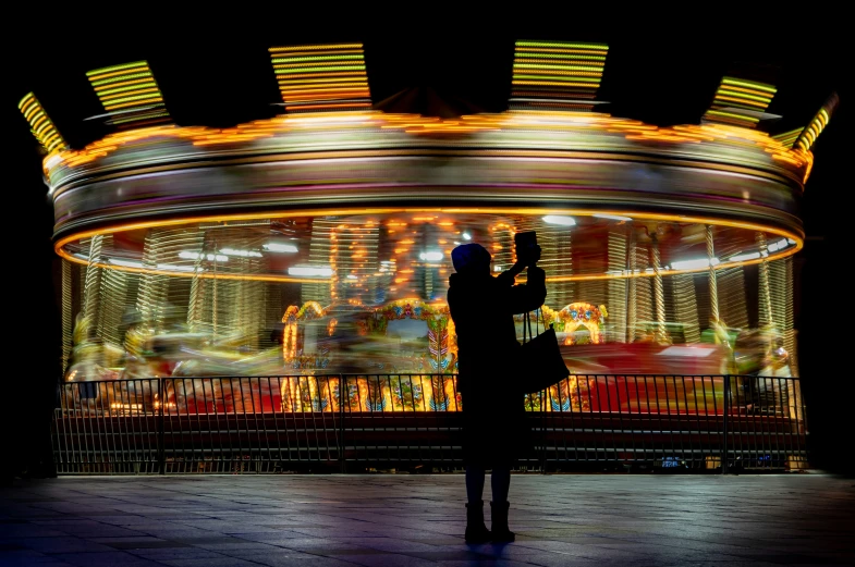 a man is taking pictures on his phone of the carousel