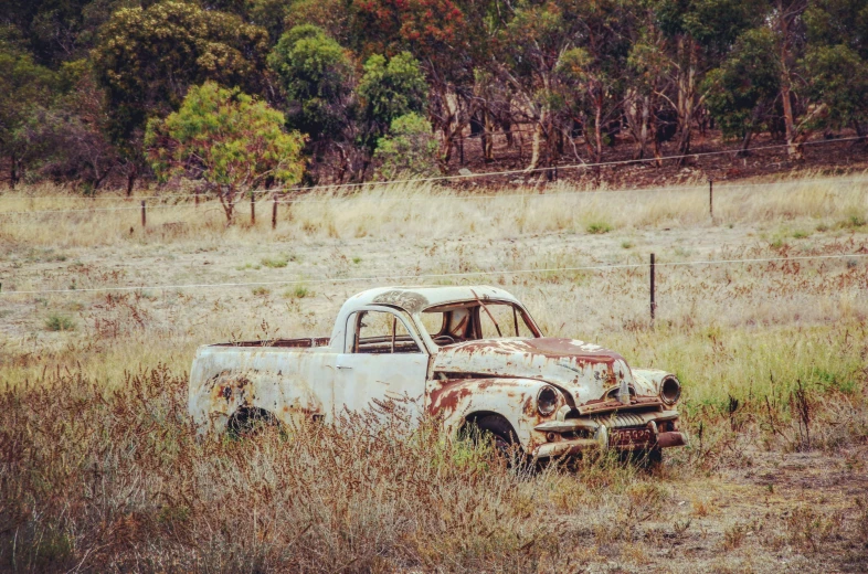 an old truck that is in a field