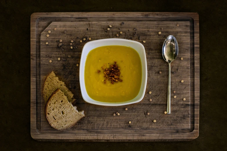 a bowl of soup is sitting next to some bread