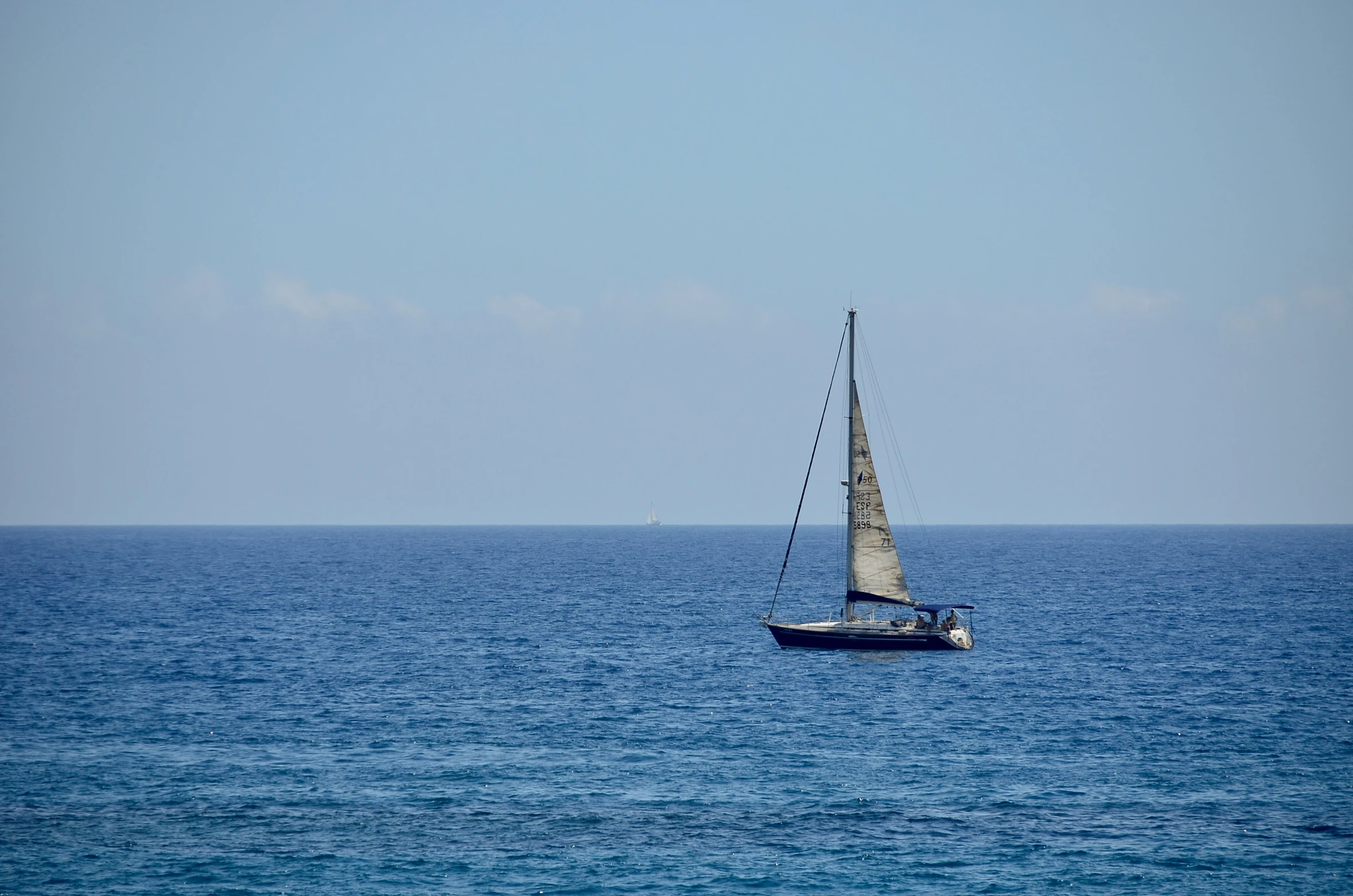 a small boat sailing along a large body of water