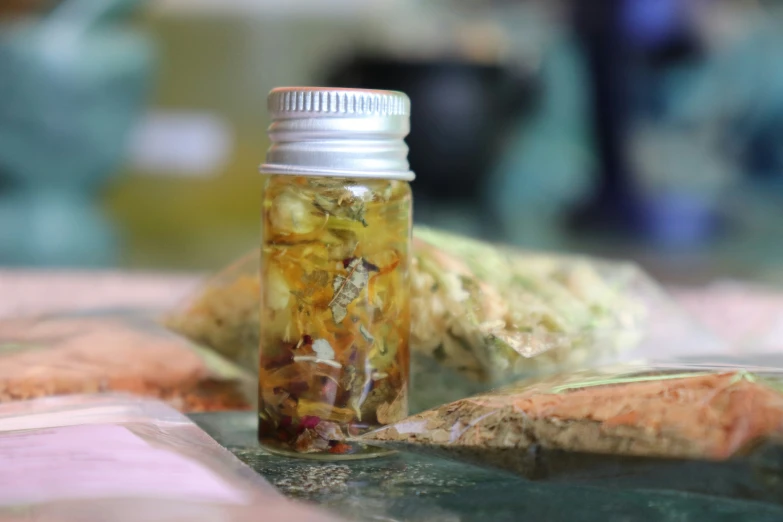 a bottle with some food in it is standing near rocks