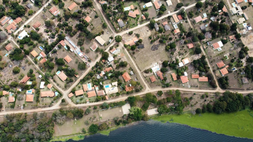 an aerial view of the outskirts of a suburb next to a large body of water