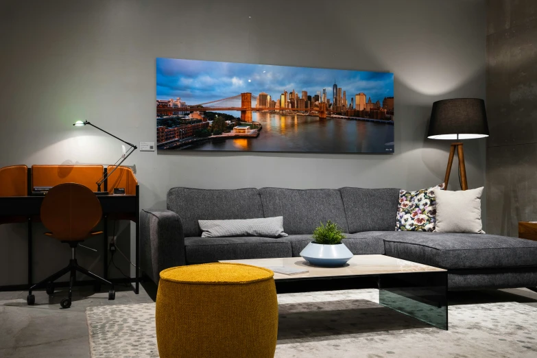 an apartment living room with a modern sofa and city art on the wall