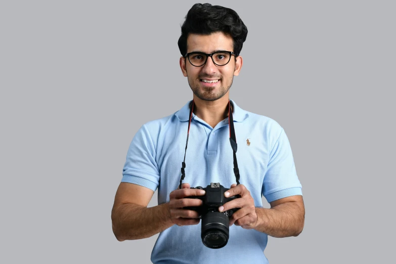 a smiling man wearing glasses and carrying a camera